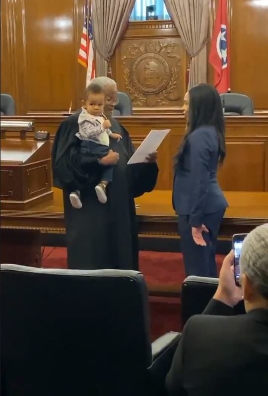 Judge bounces law student's 1-year-old baby on his hip while swearing-in his mother in heartwarming ceremony.