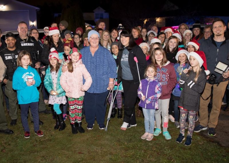 Students of beloved teacher fighting cancer show up on her front lawn to sing her Christmas carols.