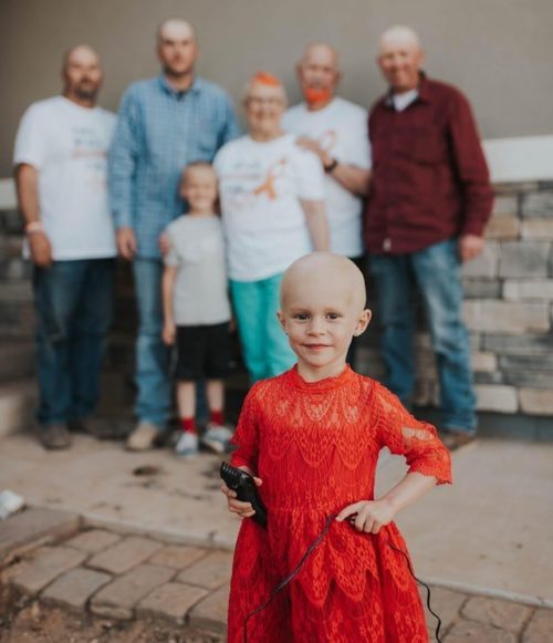 Lula Beth standing in front of family members after shaving their heads.