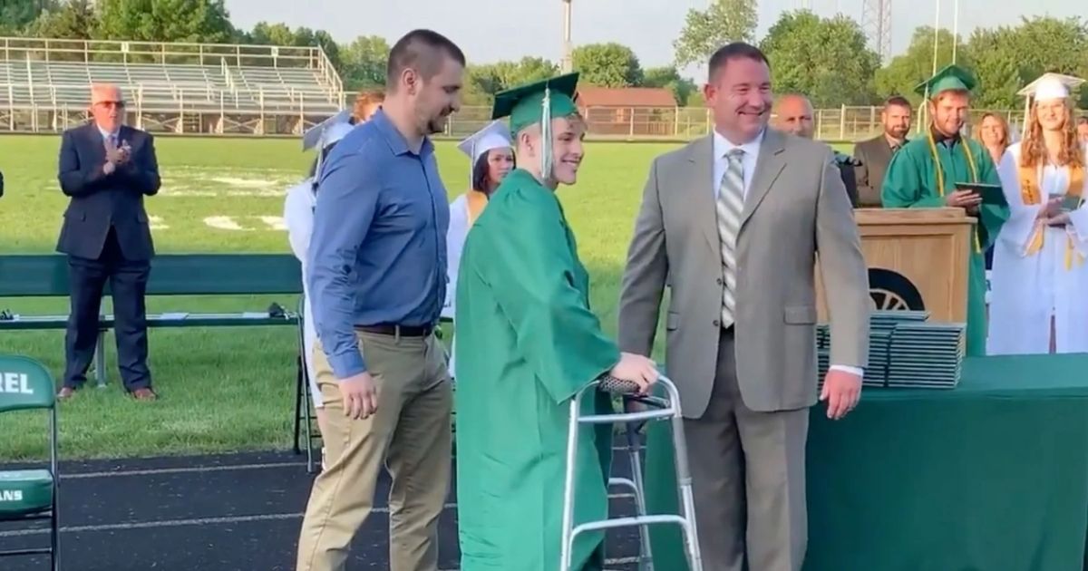 High school senior paralyzed during football game gets standing ovation as he walks at graduation 