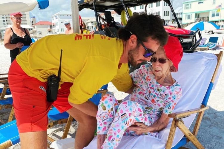 Alabama lifeguards carry 95-year-old woman down to the beach every day. 